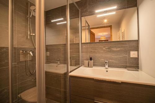 a bathroom with a sink and a shower and a tub at Résidence LUMI BATIMENT B - Appartement LUMI B pour 7 Personnes 224 in Valmorel