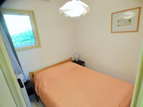 une chambre avec un lit orange et une fenêtre dans l'établissement Grande terrasse, piscines, tennis, crique, plage..., à Saint-Mandrier-sur-Mer