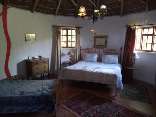 een slaapkamer met 2 bedden, een dressoir en ramen bij Gryffin Cottage at Hogwarts Forest in Hogsback