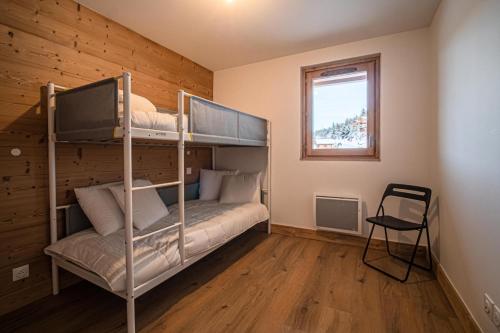 a bedroom with two bunk beds and a window at Résidence LUMI BATIMENT B - Appartement LUMI B pour 5 Personnes 024 in Valmorel