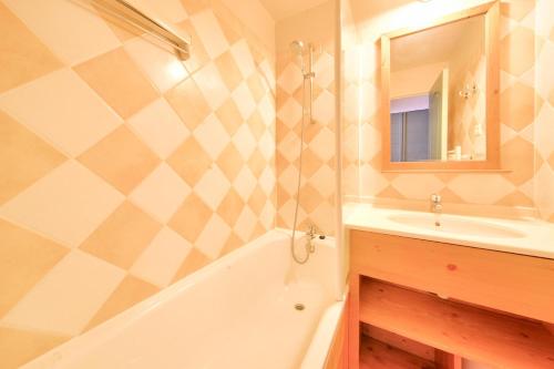 une salle de bain avec une baignoire blanche et un lavabo dans l'établissement Résidence La Marelle et Le Rami - maeva Home - Appartement 3 pièces 7 personnes - Sélection MAE-6844, à La Plagne Tarentaise