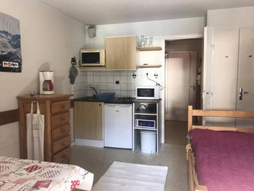 a small kitchen with a stove and a refrigerator at Résidence Andromede - Studio pour 4 Personnes 384 in Vénosc