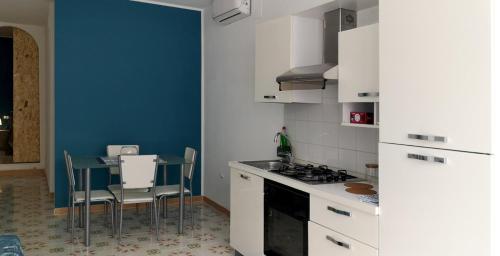 Yellow e Blu appartaments في جوليانوفا: مطبخ بطاولة وجدار ازرق