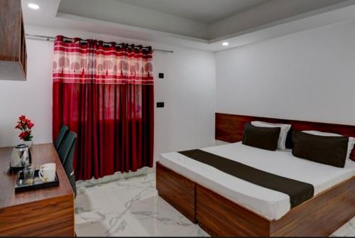 um quarto com uma cama e uma cortina vermelha em The Simran suites em Greater Noida