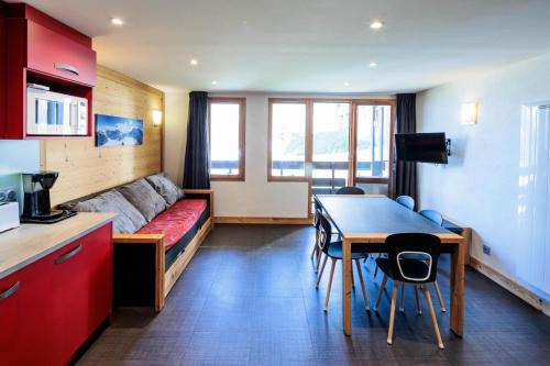 a room with a bed and a table and a kitchen at Appartement rénové 3 Pièces 4-6 Personnes in La Plagne Tarentaise