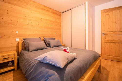 a bed with a stuffed animal sitting on top of it at Résidence LUMI BATIMENT B - Appartement LUMI B pour 4 Personnes 004 in Valmorel