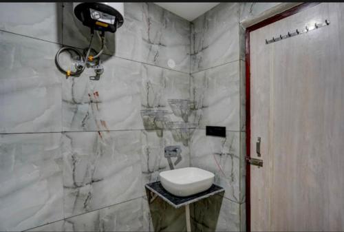 a bathroom with a white sink and a toilet at The Simran suites in Greater Noida