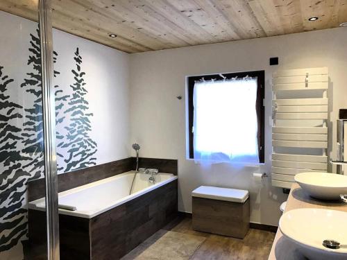 a bathroom with a tub and a toilet and a sink at Chalet Gaspard - Chalets pour 16 Personnes 494 in Vénosc