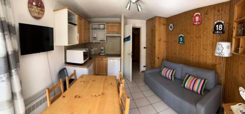 een woonkamer met een bank en een houten tafel bij Résidence Grande Chaume - 2 Pièces pour 4 Personnes 344 in Vénosc