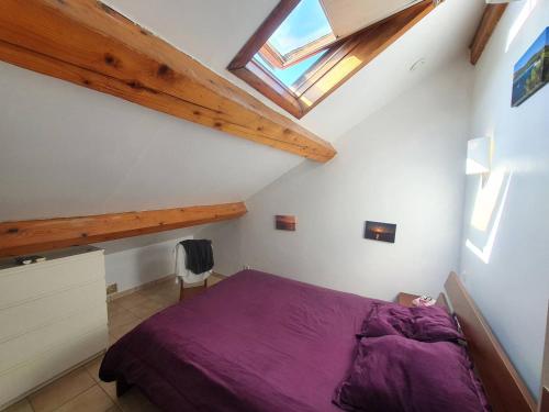 - une chambre mansardée avec un lit violet dans l'établissement Face à la plage de sable, climatisation, internet, 3 chambres, à Saint-Mandrier-sur-Mer