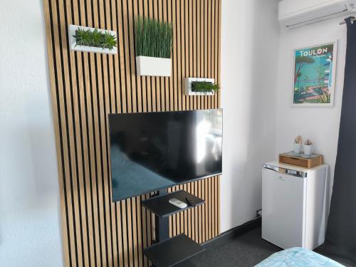 ein Wohnzimmer mit einem großen Flachbild-TV an der Wand in der Unterkunft Les Résidences du Mourillon in Toulon