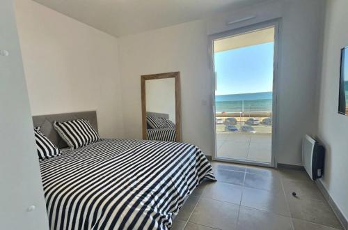 une chambre avec un lit et une vue sur l'océan dans l'établissement Capri Gra, à Valras-Plage