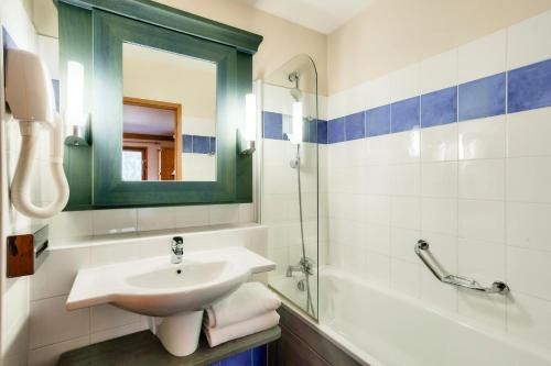 a bathroom with a sink and a mirror and a tub at Résidence Les Arcs 1950 Le Village - maeva Home - Appartement 3 Pièces 6 Personnes - Sélection MAE-4534 in Bourg-Saint-Maurice