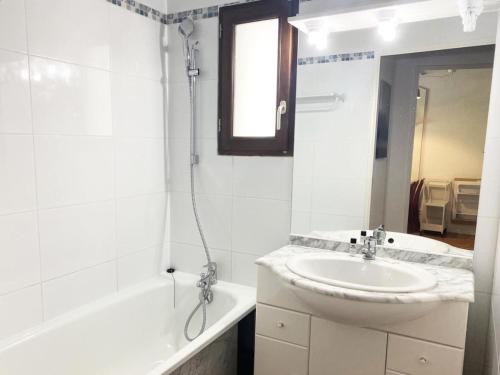 a white bathroom with a sink and a bath tub at Résidence Pic Du Midi - Apt n°126 - 1er étage - Bâtiment Gavarnie MAE-4124 in La Mongie