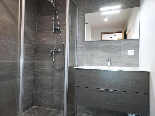 ein Bad mit einer Dusche und einem Waschbecken in der Unterkunft Résidence LUMI BATIMENT B - Appartement LUMI B pour 4 Personnes 754 in Valmorel