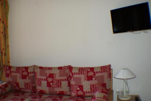 un salon avec un canapé et une télévision sur un mur dans l'établissement Résidence Le Hameau du Sauget - maeva Home - Appartement duplex 2 pièces 4 personnes - Sélection MAE-2604, à La Plagne Tarentaise