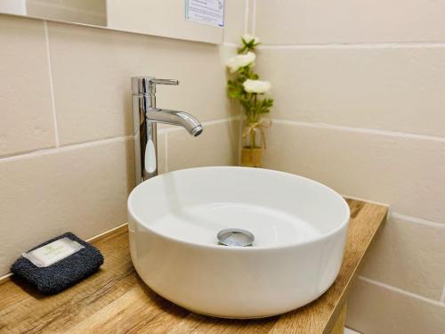 un lavandino bianco posto su un bancone in legno in bagno di ''Ophélia 22'' Joli T2 avec clim et parking a Sète
