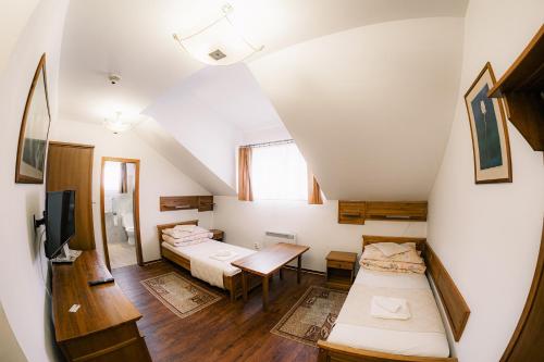 a attic room with two beds and a table at U GORAĽA in Lesnica