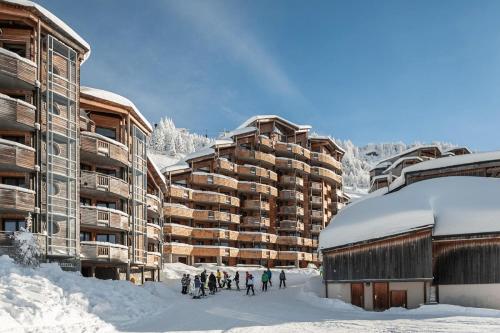 a group of people standing in the snow in front of a building at Résidence Arietis - Atria-Crozats - maeva Home - Appartement 3 pièces 7 pe 914 in Morzine