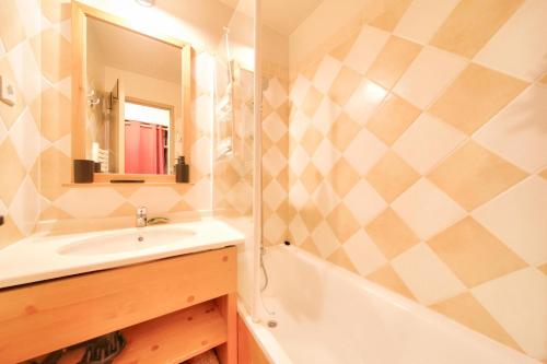 une salle de bain avec un lavabo, une baignoire et un miroir dans l'établissement Résidence La Marelle et Le Rami - maeva Home - Appartement 2 pièces 4 personnes - Sélection MAE-0944, à La Plagne Tarentaise