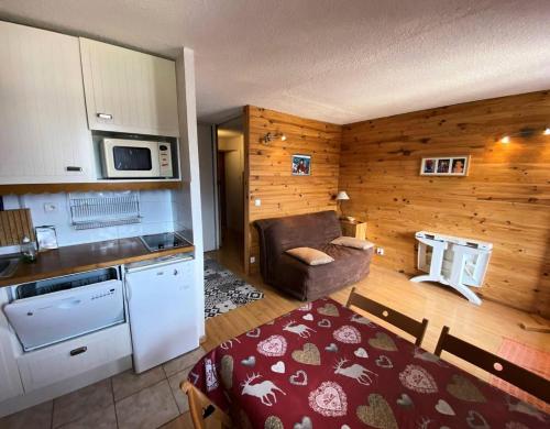 ein Zimmer mit einer Küche und einem Sofa in einem Zimmer in der Unterkunft Résidence Airelles A - 2 Pièces pour 4 Personnes 424 in Risoul