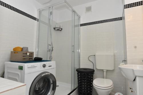 a bathroom with a washing machine and a washer at Mall Apartment 100mp in Bacău