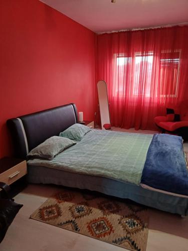 1 dormitorio con 1 cama con pared roja en Apartament Lili, en Timisoara