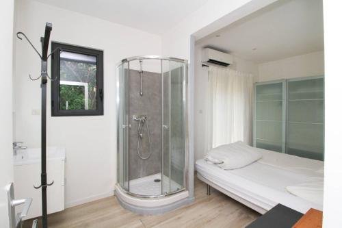 uma casa de banho com um chuveiro e uma cama. em Vue mer, contemporain, climatisation, jardin, Terrasse, 2 Salles de bains em Saint-Mandrier-sur-Mer