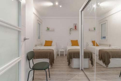 a white room with two beds and a mirror at Spacious modern-2Bedroom 2Bathroom-Bernabéu in Madrid