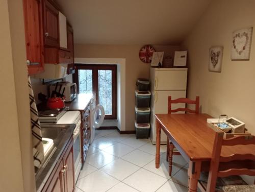 a kitchen with a table and a stove and a refrigerator at Ca di Biella in Biella