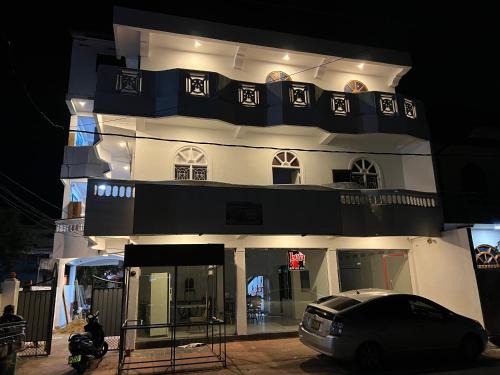 une voiture garée devant un bâtiment la nuit dans l'établissement DOCKYARD HOTEL, à Trincomalee