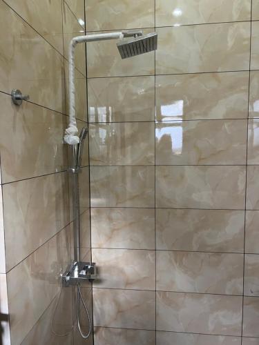 a shower with a shower head in a bathroom at DOCKYARD HOTEL in Trincomalee