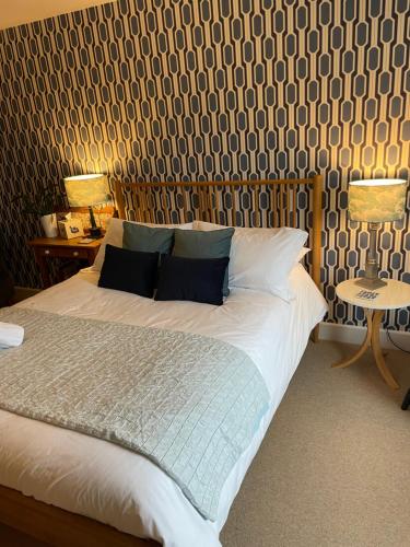 um quarto com uma cama com duas mesas e dois candeeiros em No 12 em Lyme Regis
