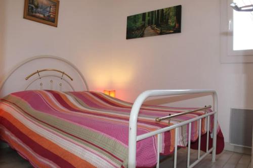 een bed met een gestreepte deken erop bij Appartement 1809 Tennis village 6 personnes in Cap d'Agde