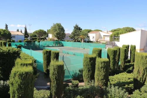 een tennisbaan met 2 tennisrackets bij Appartement 1809 Tennis village 6 personnes in Cap d'Agde
