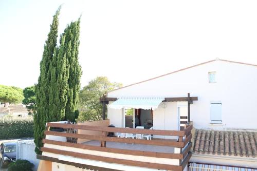 een wit huis met een houten hek ervoor bij Appartement 1809 Tennis village 6 personnes in Cap d'Agde