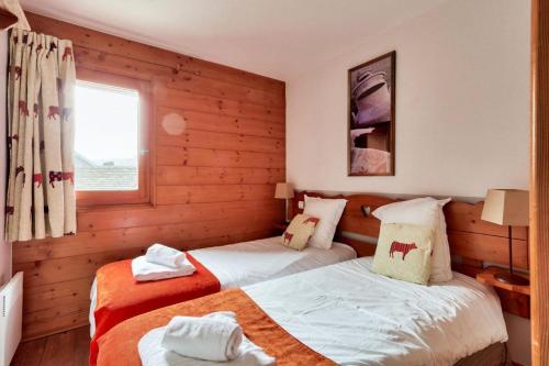 zwei Betten in einem Zimmer mit Holzwänden in der Unterkunft Résidence Les Fermes du Soleil - maeva Home - Appartement 3 pièces 6 personnes - Prestige MAE-0374 in Les Carroz d'Araches