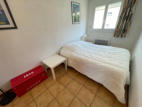 - une petite chambre avec un lit et une petite table dans l'établissement Vue mer, WIFI, coeur du village, piscine, tennis ...Tout à pied, à Saint-Mandrier-sur-Mer
