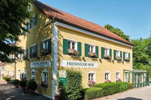 un edificio con persianas verdes y flores en él en Hotel Freisinger Hof, en Múnich