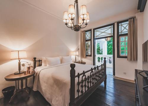 um quarto com uma cama grande e um lustre em Labrador Villa em Singapura