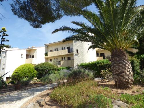 un palmier devant un bâtiment dans l'établissement Grand Studio au calme avec PISCINE et à 5 mn à pied de la PLAGE, à La Seyne-sur-Mer