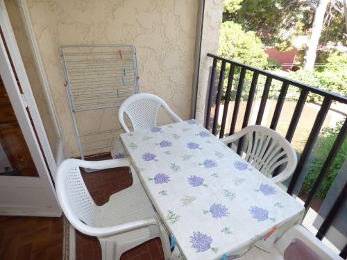 une table et deux chaises sur un balcon dans l'établissement Grand Studio au calme avec PISCINE et à 5 mn à pied de la PLAGE, à La Seyne-sur-Mer