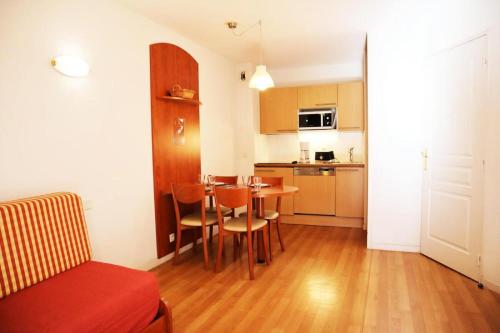 ein Wohnzimmer mit einem Tisch und einer Küche in der Unterkunft Résidence Pic Du Midi - 2 Pièces pour 4 Personnes 264 in La Mongie