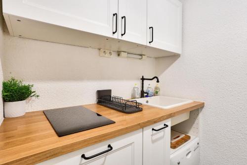 La cuisine est équipée de placards blancs, d'un évier et d'un comptoir. dans l'établissement Résidences Les Fibières - maeva Home - Appartement 2 pièces 4 personnes - Sélection MAE-4504, à Vars