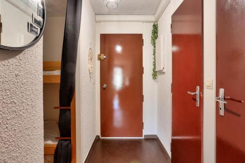 un couloir avec une porte marron dans une chambre dans l'établissement Résidences Les Fibières - maeva Home - Appartement 2 pièces 4 personnes - Sélection MAE-4504, à Vars