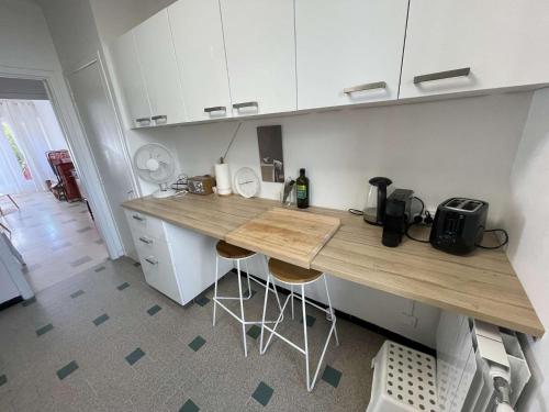 une cuisine avec un comptoir et des tabourets. dans l'établissement Appartement lumineux à deux pas de la plage, tout équipé et tout à pied !, à La Seyne-sur-Mer