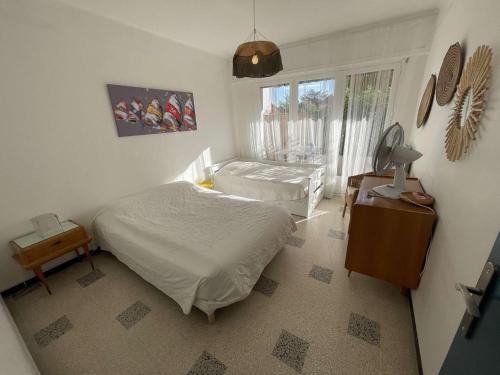 une chambre avec deux lits et une fenêtre dans l'établissement Appartement lumineux à deux pas de la plage, tout équipé et tout à pied !, à La Seyne-sur-Mer