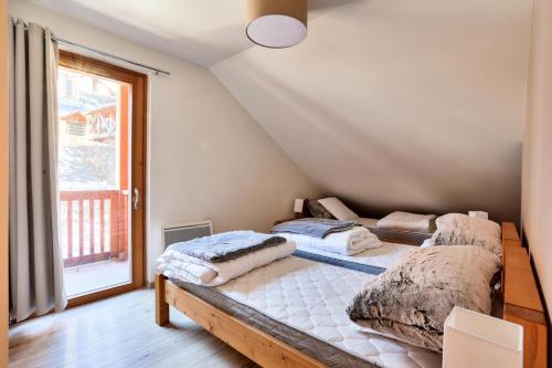 deux lits dans une chambre avec une fenêtre dans l'établissement Résidence Le Chalet des Rennes - maeva Home - Appartement 3 pièces 7 personnes - Exclusive MAE-6294, à Vars