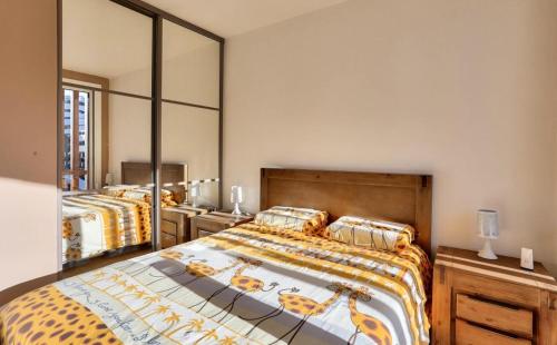 1 dormitorio con 2 camas y un espejo grande en Résidence Le Seignon - maeva Home - Appartement 3 pièces 6 personnes - Pre 054 en Vars