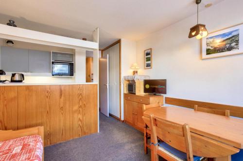 une cuisine et une salle à manger avec une table en bois dans l'établissement Quartier Crève Cœur - maeva Home - Appartement 2 pièces 5 personnes - Confort MAE-1244, à Valmorel